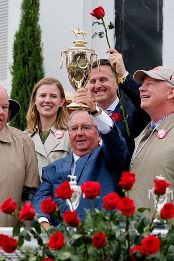 Trainer Shug McGaughey celebrates with the trophy after his horse Orb won the Kentucky Derby on May 4, 2013