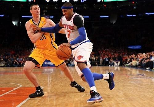 Carmelo Anthony (R) of the New York Knicks dribbles past Indiana Pacers' Tyler Hansbrough in New York on May 5, 2013