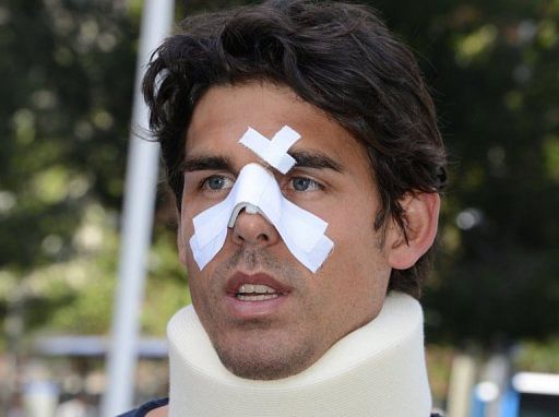 Thomas Drouet, training partner of Bernard Tomic, leaves a Madrid courthouse with a bandage and brace on May 6, 2013