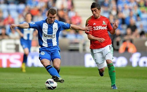 Wigan Athletic&#039;s Callum McManaman (L) is challenged by Swansea City&#039;s Pablo Hernandez in Wigan on May 7, 2013