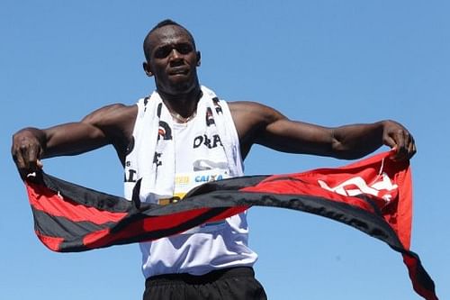 Usain Bolt waves a flag of Brazilian football club Flamengo at the end of a race on Copacabana Beach on March 31, 2013