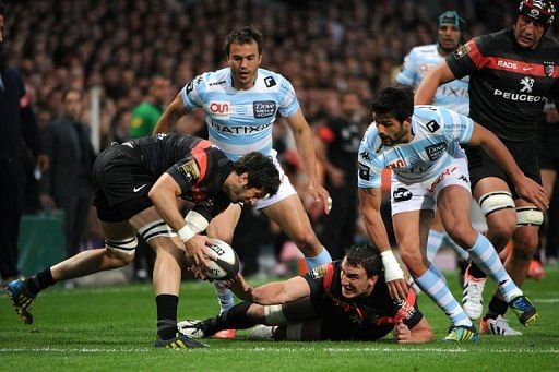 Toulouse&#039;s Louis Picamoles (C, on the ground) passes the ball to teammate Jean Bouilhou (L) on May 10, 2013