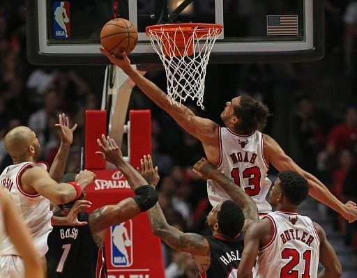 Joakim Noah of the Chicago Bulls puts up a shot over Chris Bosh (L) and Udonis Haslem of the Miami Heat on May 10, 2013