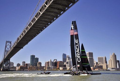 The Oracle team sails their AC-72 yacht under the Bay Bridge in San Francisco on April 17, 2013