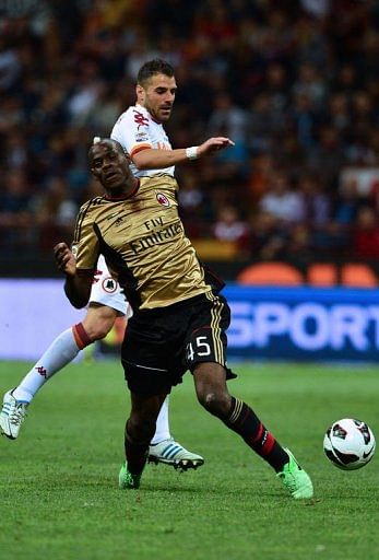 AC Milan&#039;s Mario Balotelli  (R) fights for the ball with AS Roma&#039;s Simone Perrotta in Milan on May 12, 2013