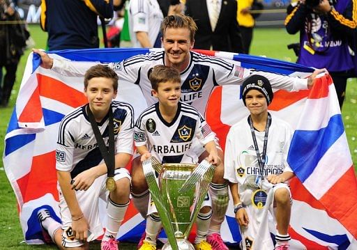 David Beckham poses with his sons Brooklyn (L), Cruz (C) and Romeo and the MLS Trophy on December 1, 2012 in Carson