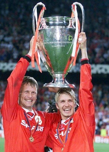 Manchester United&#039;s Teddy Sheringham (L) and David Beckham hold aloft the Champions League Cup on May 26, 1999