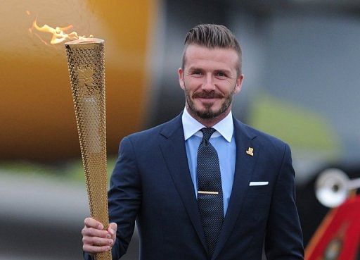 David Beckham carries the Olympic torch as it arrives at RNAS Culdrose air base in Cornwall on May 18, 2012