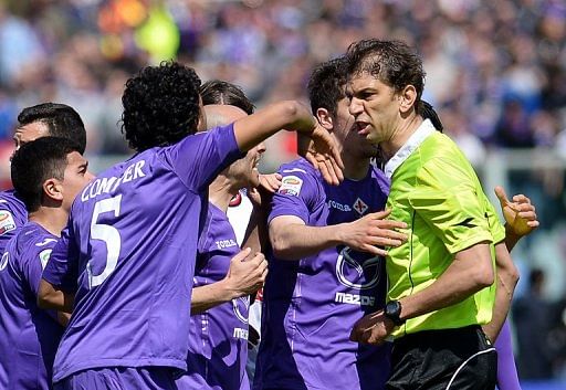 Fiorentina players argue with referee Paolo Tagliavento (R)  April 7, 2013 during the match against AC Milan in Florence