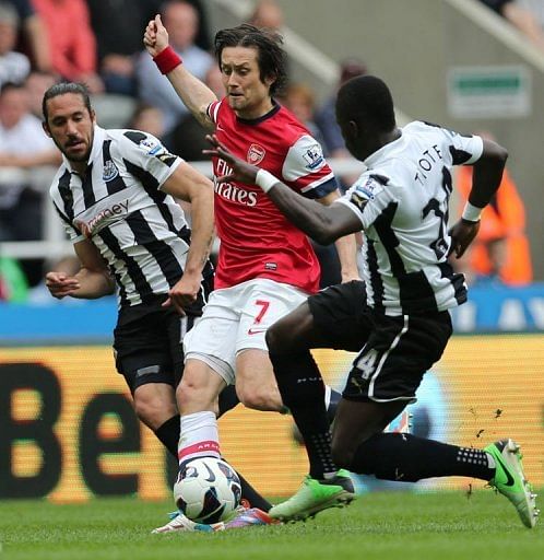 Arsenal&#039;s Tomas Rosicky (C) competes with Newcastle United&#039;s Cheick Tiote (R) and Jonas Gutierrez (L) on May 19, 2013