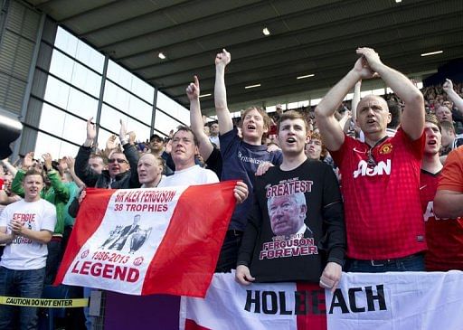 Manchester United fans sing after their team scored in West Bromwich on May 19, 2013