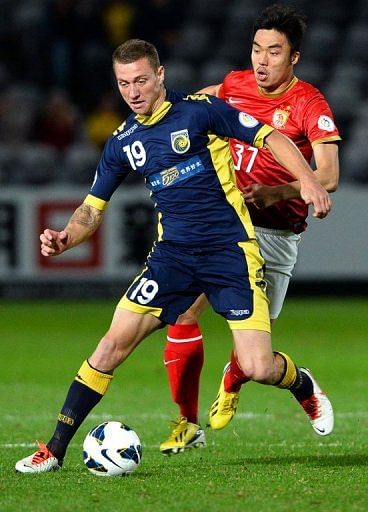 Central Coast Mariners&#039; Mitchell Duke (L) and Guangzhou&#039;s Zhoa Xuri are pictured during their match on May 15, 2013
