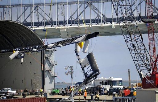 Workers for Artemis and America&#039;s Cup use a crane to lift the damaged Regata, in San Francisco, on May 10, 2013