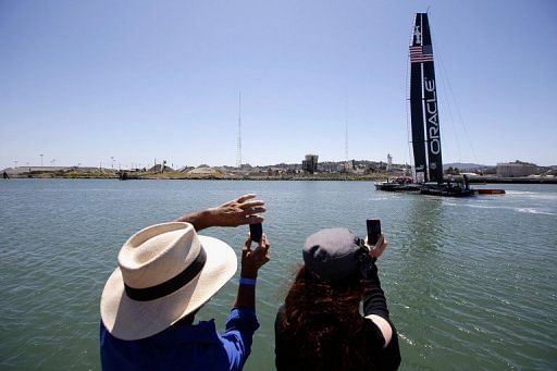 People take photos of the new Oracle Team USA AC72, in San Francisco, California, on April 23, 2013