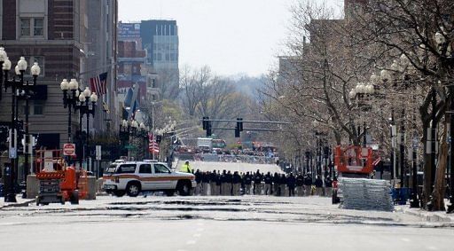 Law enforcement officials hold a moment of silence near the Boston Marathon finish line on April 22, 2013 in Boston
