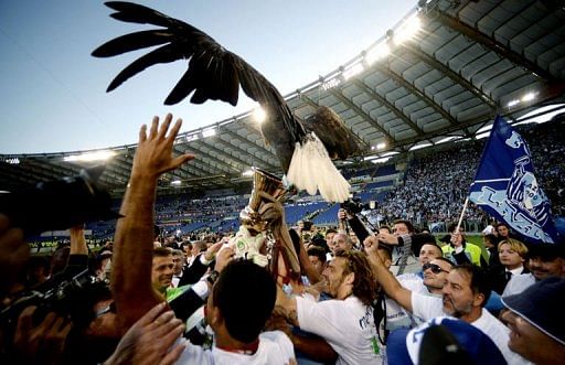 Lazio&#039;s players hold the trophy with an eagle, the team&#039;s mascot, to celebrate victory on May 26, 2013 in Rome