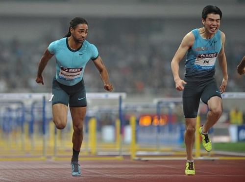 Jason Richardson of the US (L) and China's Xie Wenjun compete in the 110m hurdles event in Shanghai, on May 18, 2013