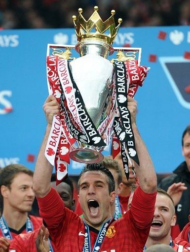 Manchester United striker Robin van Persie lifts the Premier League trophy at Old Trafford on May 12, 2013