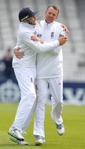 Graeme Swann (R) celebrates with Joe Root after the dismissal of New Zealand's Hamish Rutherford on May 27, 2013