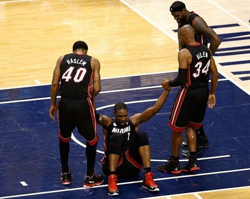 Miami Heat's Chris Bosh is helped up by Udonis Haslem (L) and Ray Allen during the game against Indiana on May 28, 2013