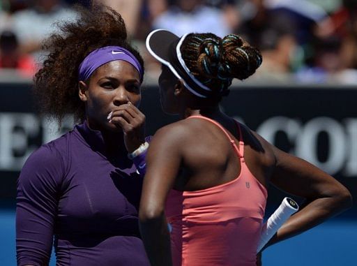 Serena Williams speaks with sister Venus Williams during a match at the Australian Open in Melbourne on January 22, 2013