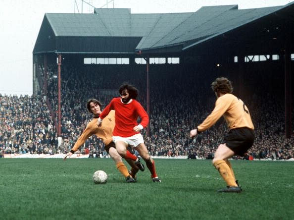 Football. Manchester United&#039;s George Best is tackled by Wolverhampton Wanderer&#039;s McCalliog from behind during their league match at Old Trafford, 1971.