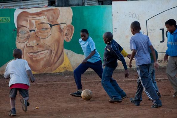 Children play football in front of a por
