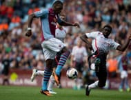 Christian Benteke of Aston Villa is challenged by Kolo Toure of Liverpool