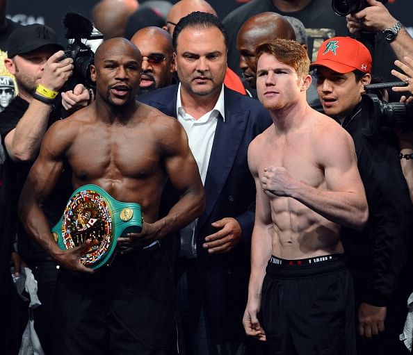 Floyd Mayweather Jr. (L) and Canelo Alvarez (R) pose during the official weigh-in for their bout at the MGM Grand Garden Arena