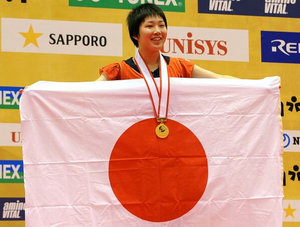 16-year-old Akane Yamaguchi of Japan (R) shows her national flag on the podium after her women&#039;s singles final at the Japan Open 2013 in Tokyo on September 22, 2013. (Getty Images)