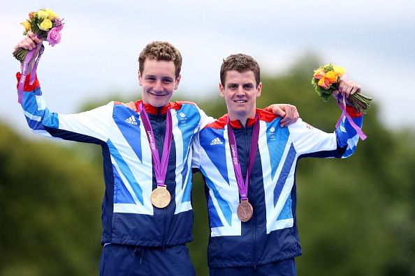 Alistair Brownlee (L) poses with his gold medal next to his brother and bronze medalist Jonathan Brownlee at last year&#039;s Olympics