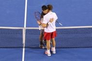MELBOURNE, AUSTRALIA - JANUARY 21: Stanislas Wawrinka of Switzerland is hugged by Novak Djokovic of Serbia after winning their quarterfinal match during the 2014 Australian Open