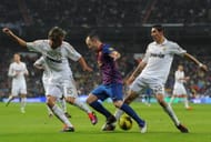 Andres Iniesta (C) of FC Barcelona duels for the ball with Fabio Coentrao (L) and Angel Di Maria of Real Madrid