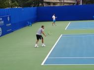 The grim Mikhail Youzhny and the casual Fabio Fognini on the practice courts