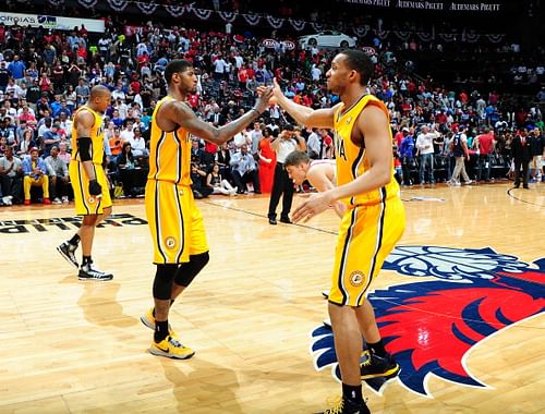 Paul George #24 and Evan Turner #12 of the Indiana Pacers slap hands during a game against the Atlanta Hawks during Game Four of the Eastern Conference Quarterfinals on April 26, 2014 at Philips Arena in Atlanta, Georgia.