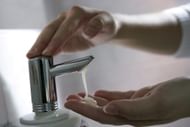 GERMANY, BONN, Hands under soap dispenser with liquid soap before washing the hands.