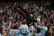 Manchester City players celebrate their title victory with their coaching staff