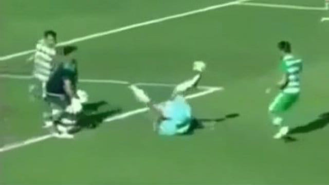 Player lobs the goalkeeper while upside down on the ground