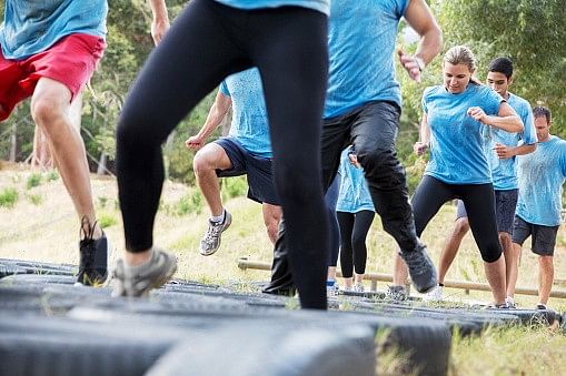 People jumping tires on boot camp obstacle course