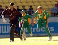 WELLINGTON, NEW ZEALAND - FEBRUARY 20: South Africa's Shaun Pollock, right, bowls past New Zealand's Stephen Fleming in the third one day international cricket match at Westpac Stadium, Wellington, New Zealand, Friday, Feb 20, 2004. (Photo by Ross Setford/Getty Images)