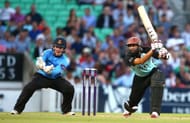 LONDON, ENGLAND - JUNE 13: Hashim Amla of Surrey hits out while Ben Brown of Sussex looks on during the Natwest T20 Blast match between Surrey and Sussex Sharks at The Kia Oval on June 13, 2014 in London, England. (Photo by Charlie Crowhurst/Getty Images)