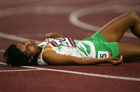 DOHA, QATAR - DECEMBER 11:  P. Jaisha Orchatteri of India #2098 lays on the track after finishing third for the bronze medal in the Women&#039;s 5000m during the 15th Asian Games Doha 2006 at the Khalifa Stadium December 11, 2006 in Doha, Qatar.   (Photo by Clive Rose/Getty Images for DAGOC)