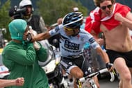 Alberto Contador (C) punches a fan dressed up as a doctor as he climbs Alpe d'Huez (1850 m) in the109,5 km and nineteenth stage of the 2011 Tour de France