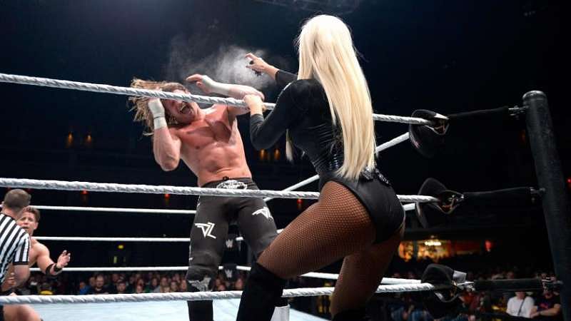 Maryse spraying Dolph Ziggler as referee attends to The Miz.