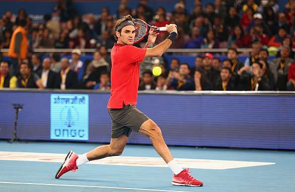 DELHI, INDIA - DECEMBER 08:  Roger Federer of the Indian Aces plays a backhand against Novak Djokovic of the UAE Royals during the Coca-Cola International Premier Tennis League third leg at the Indira Gandhi Indoor Stadium December 8, 2014 in Delhi, Delhi.  (Photo by Clive Brunskill/Getty Images for IPTL 2014)