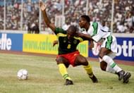 MONASTIR, TUNISIA - FEBRUARY 8: Kanu of Nigeria tries to break through the Cameroon defence during the African Nations Cup 2004 1/4 Final match between Cameroon and Nigeria at the Mustapha Ben Jannet Stadium on February 8, 2004 in Monastir, Tunisia. (Photo by Shaun Botterill/Getty Images)