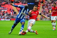 LONDON, ENGLAND - APRIL 12: Marc-Antoine Fortune of Wigan Athletic is tackled by Thomas Vermaelen of Arsenal during the FA Cup Semi-Final match between Wigan Athletic and Arsenal at Wembley Stadium on April 12, 2014 in London, England. (Photo by Mike Hewitt/Getty Images)