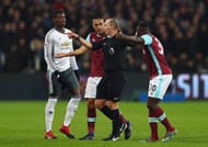 STRATFORD, ENGLAND - JANUARY 02: Referee Mike Dean is confronted by Winston Reid and Michail Antonio of West Ham United as Paul Pogba of Manchester United looks on during the Premier League match between West Ham United and Manchester United at London Stadium on January 2, 2017 in Stratford, England. (Photo by Ian Walton/Getty Images)