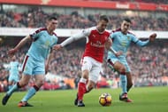 LONDON, ENGLAND - JANUARY 22: Aaron Ramsey (C) of Arsenal controls the ball under pressure of Michael Keane (L) and Matthew Lowton (R) of Burnley during the Premier League match between Arsenal and Burnley at the Emirates Stadium on January 22, 2017 in London, England. (Photo by Julian Finney/Getty Images)