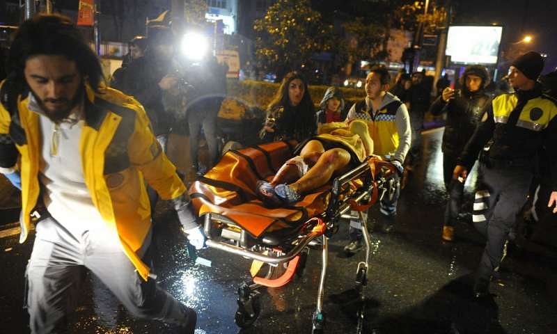 Injured people being carried away by medics from the crime scene